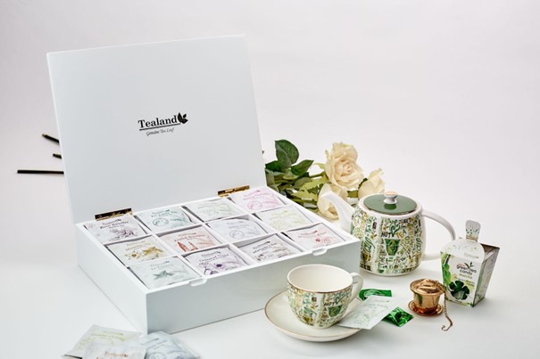 A wooden tea box filled with assorted tea bags.